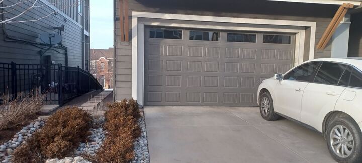 Residential gray garage door with top windows
